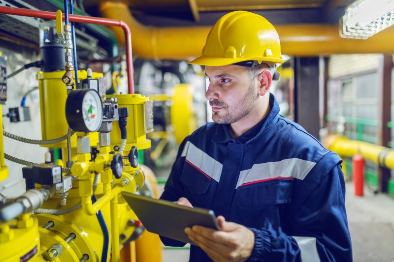 Man checks valves and reports to incident management software. 