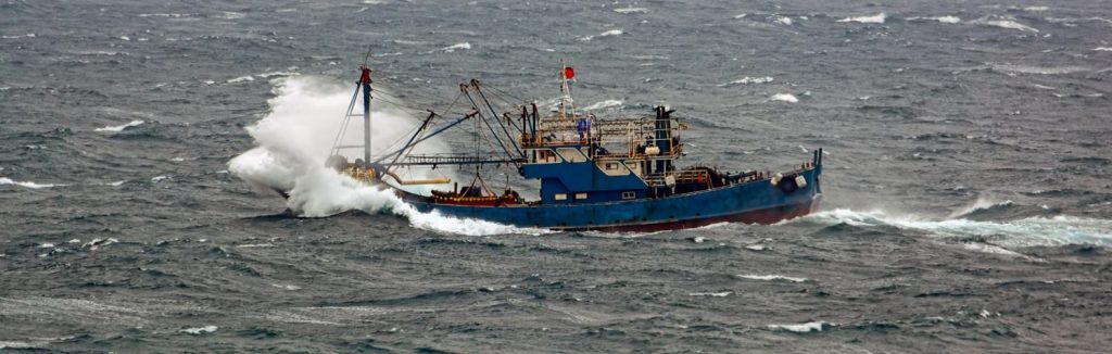 Small chinese trawler pounds through rough seas as it crosses the South China sea.