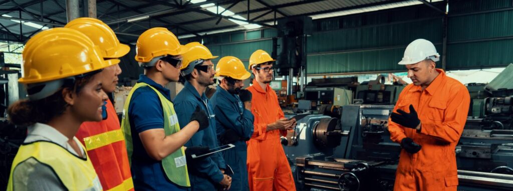 Skillful worker attending brief meeting in the factory . Industrial people and manufacturing labor concept .