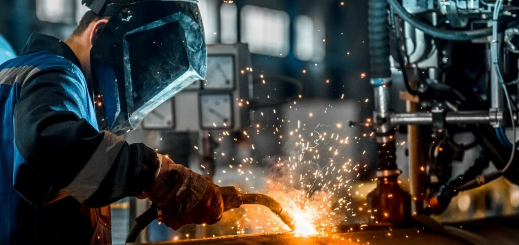 Welder uses safe practices to weld in a manufacturing plant. 